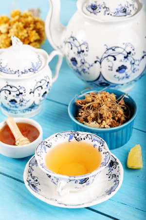 Cup of Linden Tea, Dried Linden Flowers in bowl with honey and lemon on wooden backgroundの写真素材