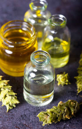 Glass bottle of essential oil with sage plant. Dried herbs with essential oils for aromatherapy treatment.の写真素材