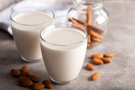 Homemade organic almond milk in a glass on stone background with cinnamon sticks.の写真素材