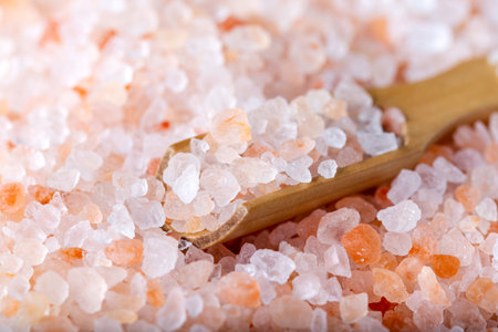 Pink Himalayan salt. Himalayan salt pile. Pink crystal salt in wooden spoon. Food background. Close up.の写真素材