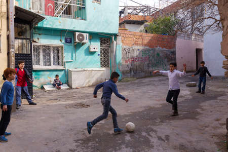 Basmane, Izmir - Turkey - 02-23-2018: Basmane is one of the oldest districts that still preserves its history. Old houses now mostly inhabited by syrian refugees. Children playing soccer on sunny day.のeditorial素材