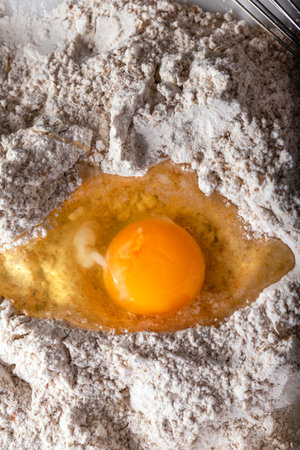 Broken egg on flour on marble background.の写真素材