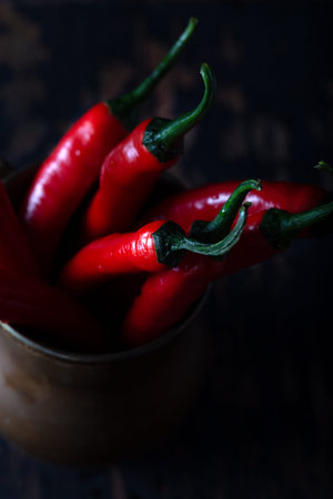 Fresh red hot peppers in an old metal jug.