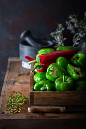 Fresh green bell pepper and red pepper in wooden box. Food preparation with fresh green bell pepper.の写真素材
