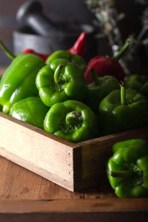 Fresh green bell peppers in wooden boxの写真素材