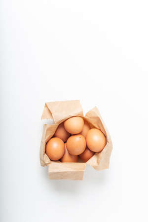 Brown eggs in paper pack on a white background.の写真素材
