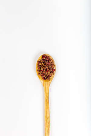 Whole Dried Sumac Berry Seeds (Rhus) in wooden spoon. Top View. Isolated on White Background.の写真素材