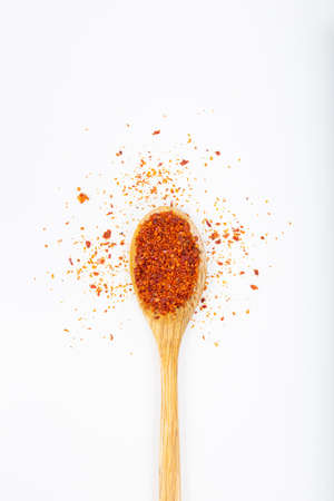 Red chili pepper in wooden spoon on white background.の写真素材