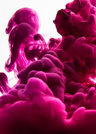 Color drop in water, photographed in motion. pink ink in water isolated on white background....