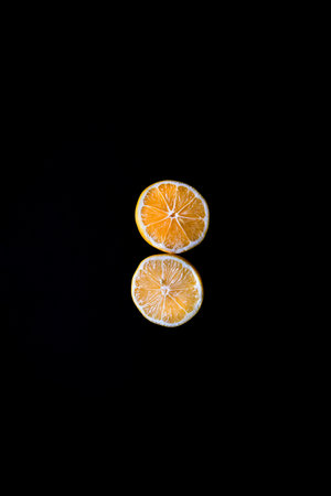 Fresh lemon slices on black background.