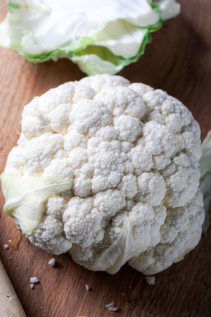 Fresh whole cauliflower on cutting board. White cauliflower on the wooden board with a knife.の写真素材