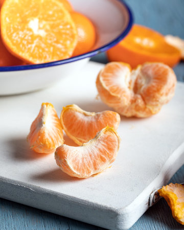 Slices of ripe yellow mandarin on a wooden table. Citrus fruits, tangerines, or oranges.の写真素材