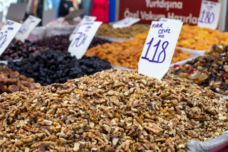 Dried fruits and nuts at a local food market in Izmir, Turkey. Heaps of open walnuts on a market stall.の写真素材