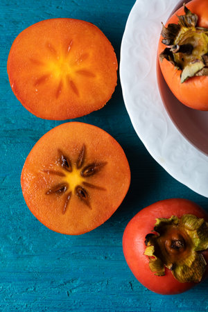 Fresh juicy tangerines in a blue ceramic bowl on wooden background. Close-up.