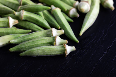 Fresh okra on black stone background, close up, top viewの写真素材