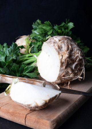 Fresh celery root on a cutting board with parsley and knifeの写真素材