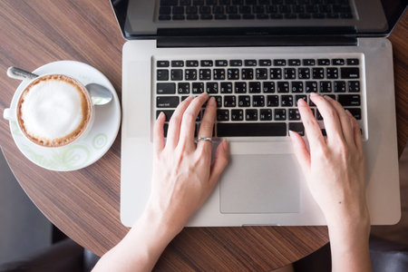 coffee cub with blur background woman who play smartphone