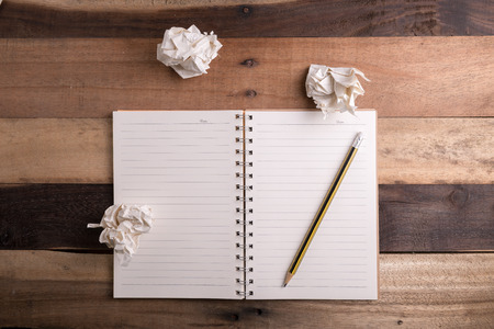 Office workspace with notepad and pencil on wood table.の写真素材