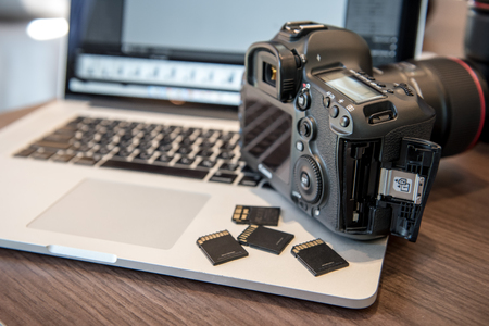 Digital Photography Workstation. Digital DSLR Camera, Laptop Computer.の写真素材