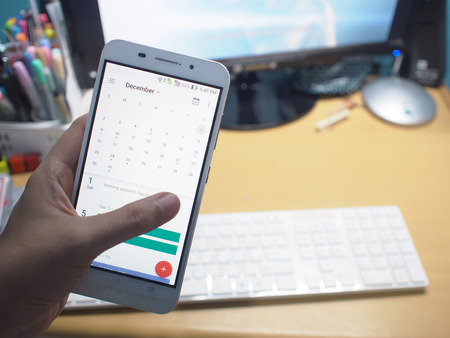 The  smartphone with working desk background.の写真素材
