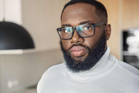 Serious young african american man in eyeglasses looking at camera closeupの写真素材