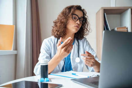 Female doctor wear white medical robe make online video call consult patient.の写真素材