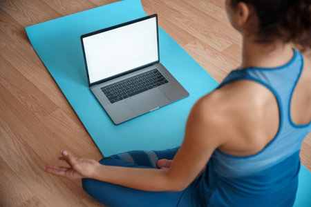 Mock up on laptop computer in front of young fit sporty woman training yoga.の写真素材