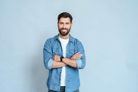 Half-body portrait of man in casual clothes isolated on blue wall backgroundの写真素材
