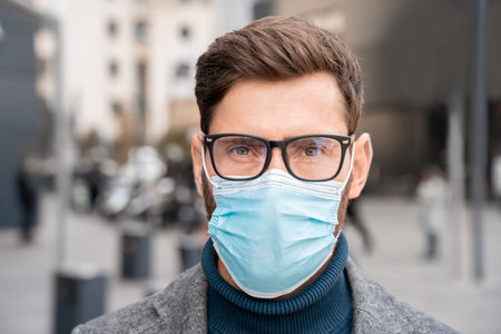 Face portrait of businessman wearing facial protective medical mask outside