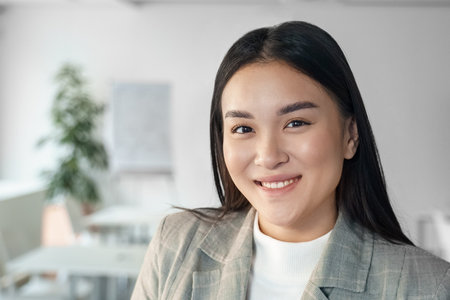 Young happy smiling asian business woman corporate staff closeup face portrait