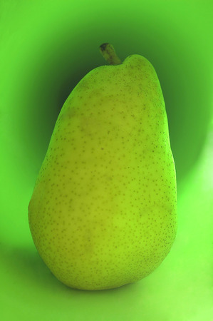 Green pear on a green backgroundの写真素材