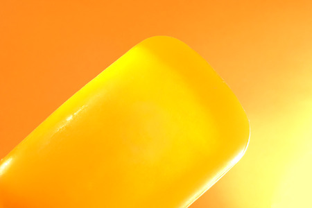 Piece of yellow soap on an orange backgroundの写真素材