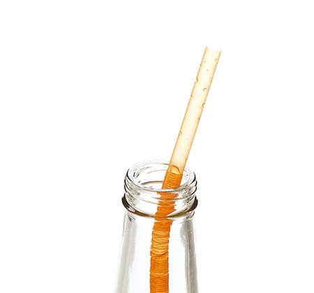 a straw in a bottle isolated on white backgroundの写真素材