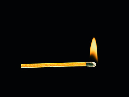 Burning match on a black background close up