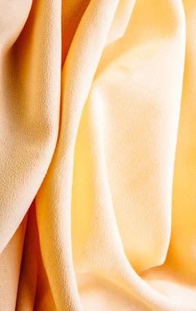 background of bright yellow silk with wavesの写真素材