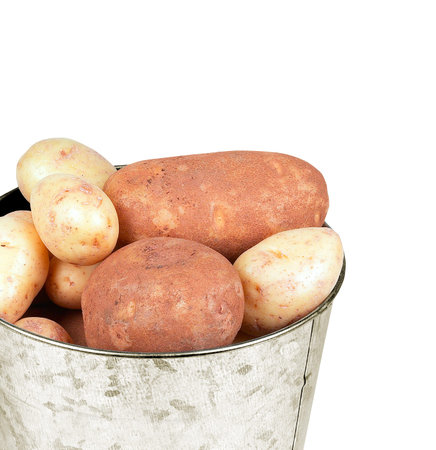Many ripe potatoes in basket isolated closeupの写真素材