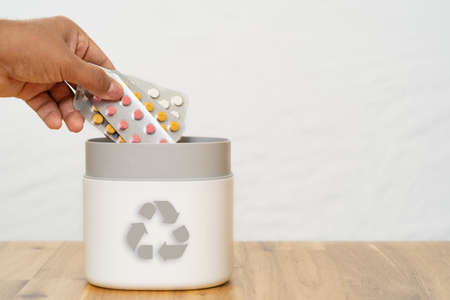 Full of expired pills and medicines in the trash bin with recycling symbol. Waste pills collected to be recycled. waste management concept.の写真素材