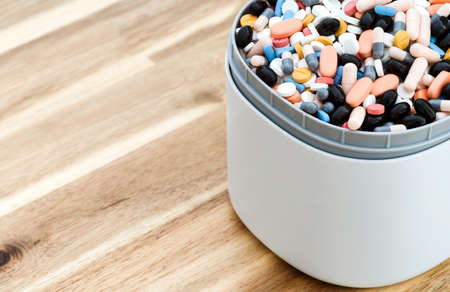 Full of expired pills and medicines in the trash bin with recycling symbol. Waste pills collected to be recycled. waste management concept.の写真素材