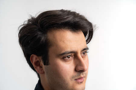 Brown skinned young adult man smiling at camera on isolated white background.の写真素材
