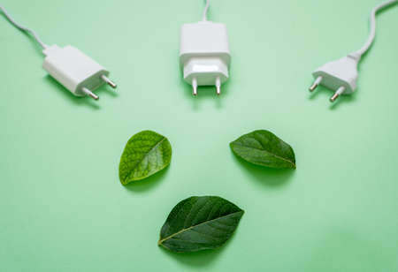 Close up photo of multiple unplugged charging sockets and green leaves. Concept of energy saving and reduce electricity usage.の写真素材