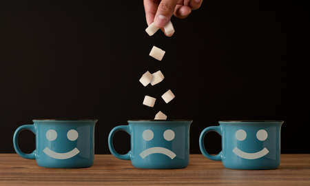 Close up photo of coffee cup and dropping sugars. concept of diabetes and overuse of sugar.の写真素材