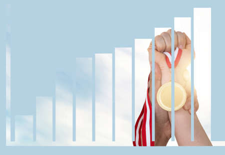 Businesswoman holding golden medal with rising chart double exposure. Concept of success of startup business and revenue, income, profit celebration.の写真素材