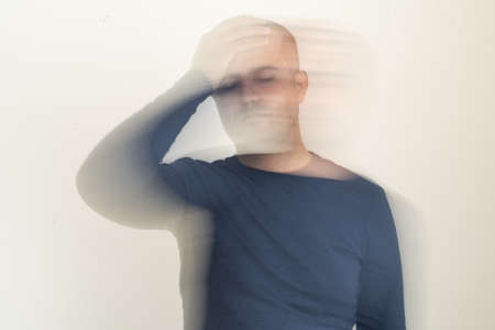 Close up photo of man with vertigo ilness. Motion blur effect intentionally applied. Dizziness and tension and medicine side effect concept.の写真素材