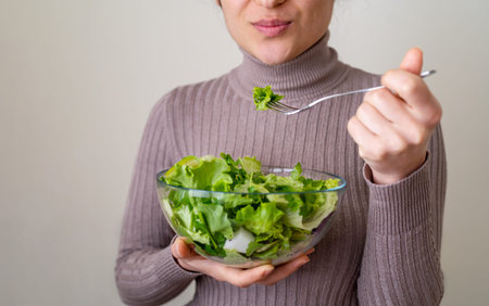 Close up photo of woman eating mediterannean salad with happy face. Concept of correct nutrition plan and diet for healthy life. selective focus.の写真素材