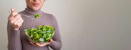 Close up photo of woman eating mediterannean salad with happy face. Concept of correct nutrition plan and diet for healthy life. selective focus.の写真素材