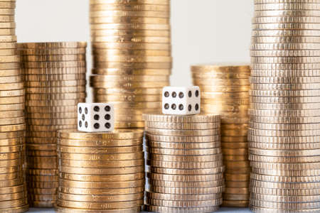 Close up photo of stacks of coins and pair of dices symbolizes role of luck in success. Gamble, bet and lottery concept.の写真素材