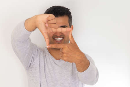 Close up photo of brown skinned young adult man with gum smiling. White teeth concept.の写真素材