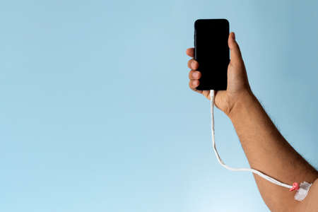 Close up photo of a hand charging mobile phoneの写真素材