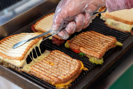 Toasted sandwiches with melting cheese on toast or grill.の写真素材