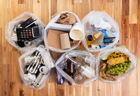 Top view photo of segregated waste materials laid on wooden background. waste management concept